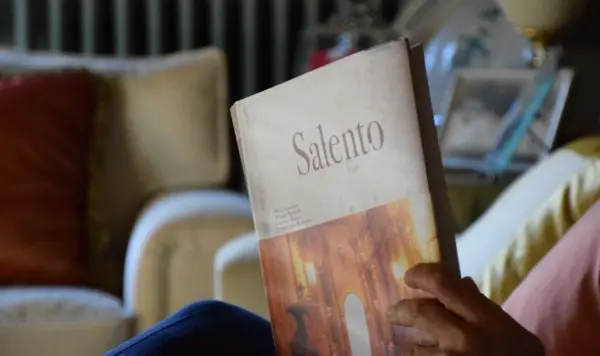 Mani che sfogliano un libro fotografico dedicato al Salento